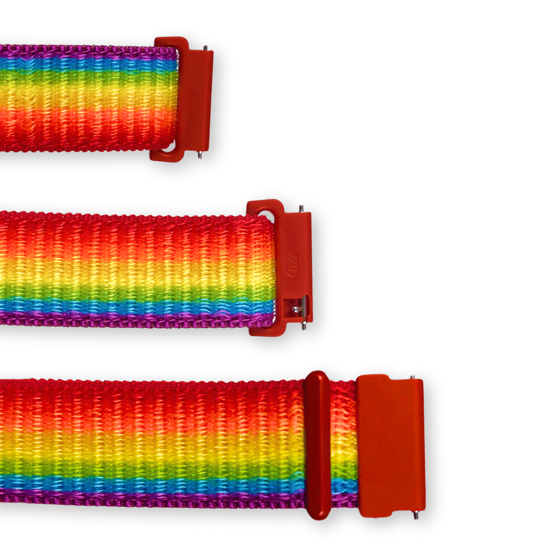 Tři části duhového textilního řemínku s plastovými červenými úchyty a kovovými čepy pro upevnění k hodinkám.