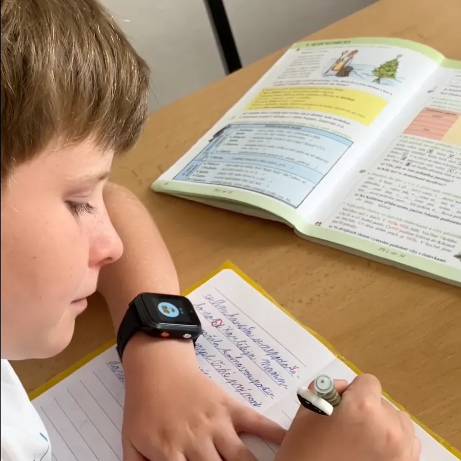 Schulkind mit KLOKI Uhr in der Schulbank